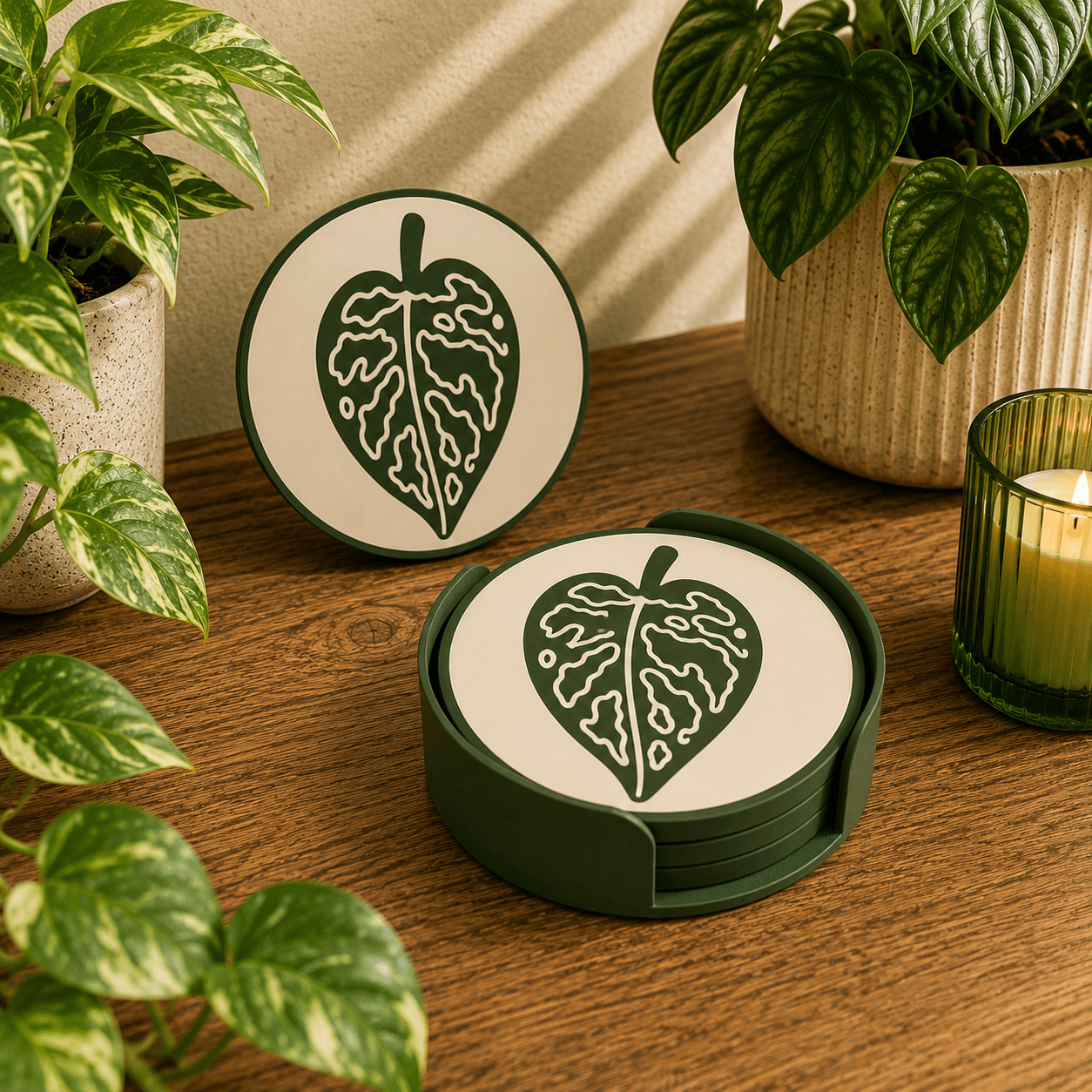 Variegated leaf design 3D printed botanical coaster with matching dark green holder, styled with houseplants and candle