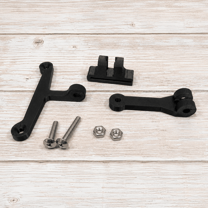 Black metal mounting brackets and silver hardware screws, nuts, and washers arranged on a light wood plank surface.