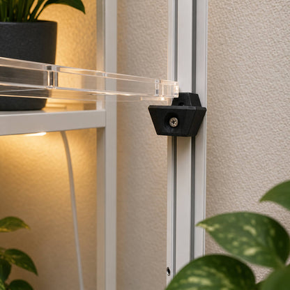 Close-up of a black bracket attached to a glass panel with plants in the background.