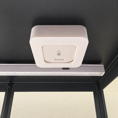 White Govee H5179 magnetic mount attached beneath a black cabinet ceiling beside an LED grow light.