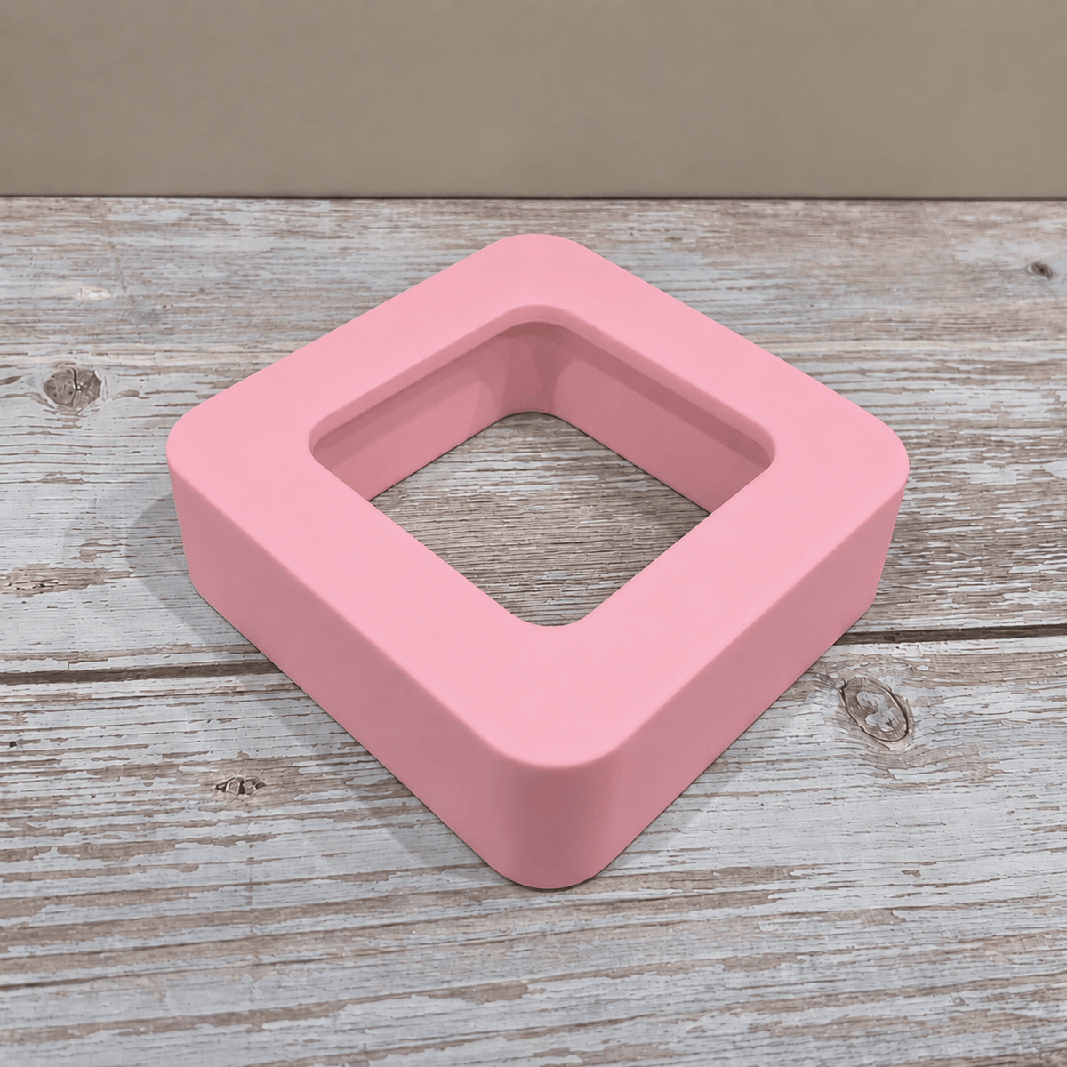 Pink Govee H5179 magnetic hygrometer mount shown without the sensor on a light wooden tabletop.