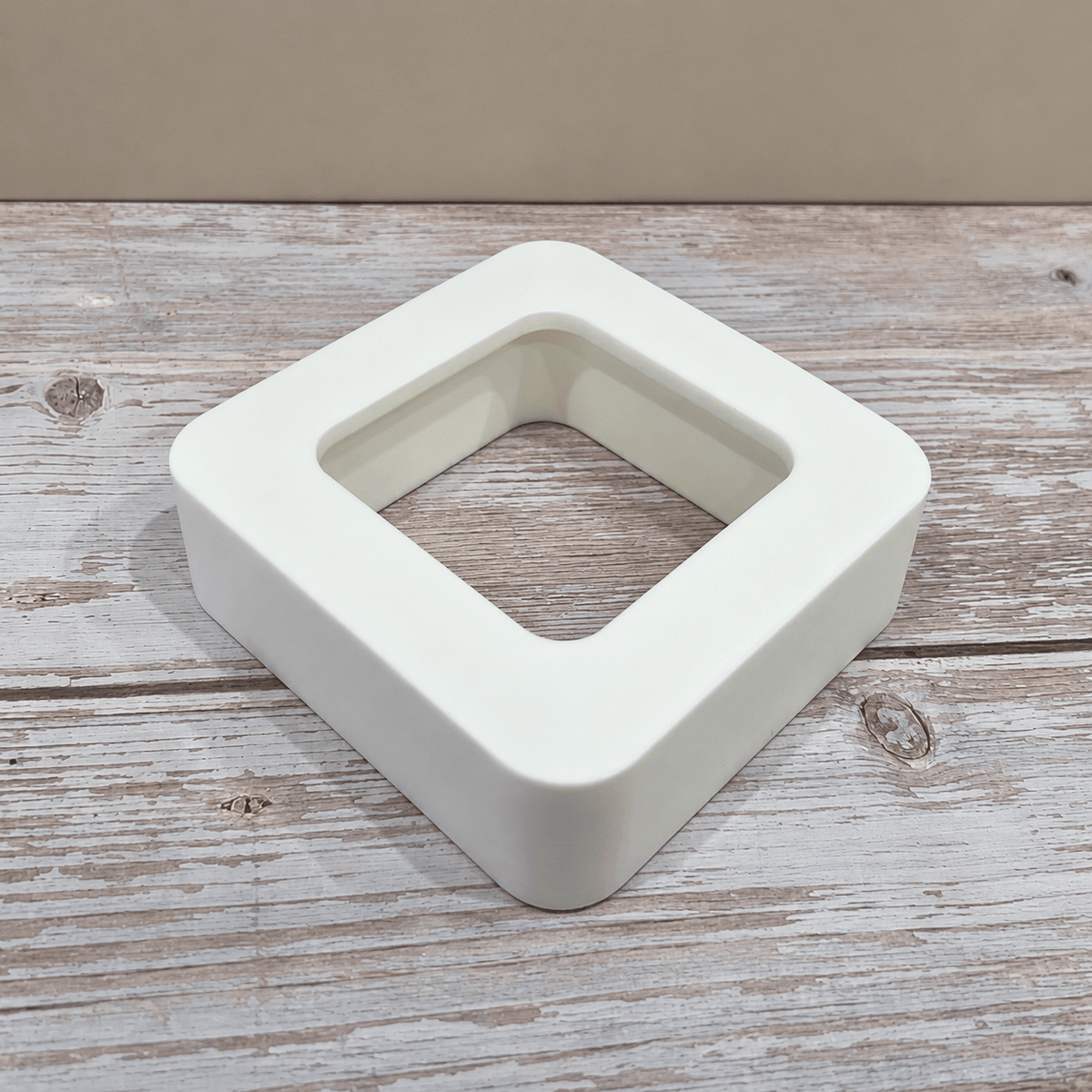 White Govee H5179 magnetic hygrometer mount shown without the sensor on a light wooden tabletop.