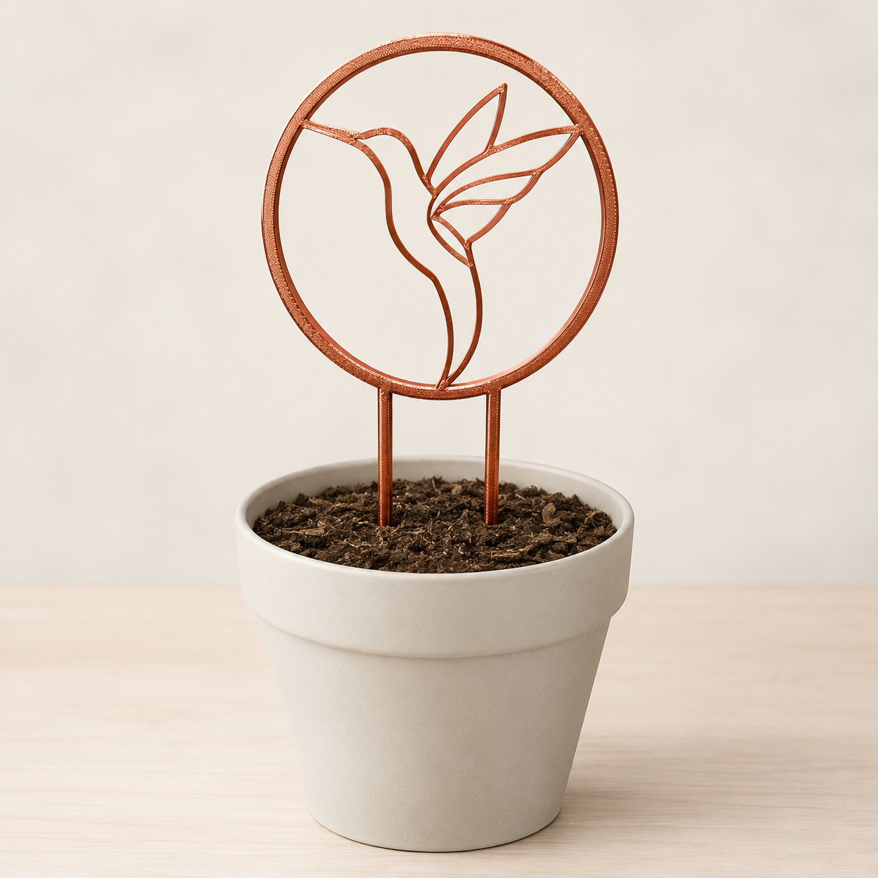 Decorative hummingbird plant trellis displayed in an indoor flowerpot