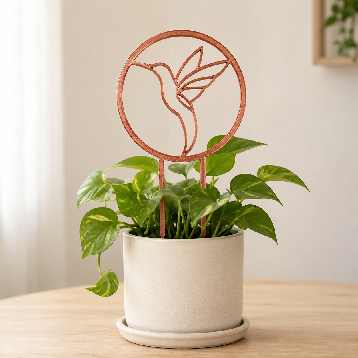 Copper silk hummingbird trellis supporting climbing vines in a ceramic planter