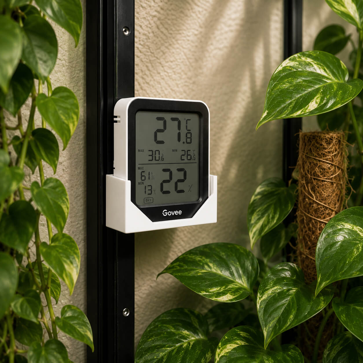 Black hygrometer corner mount installed in IKEA Milsbo cabinet with plants