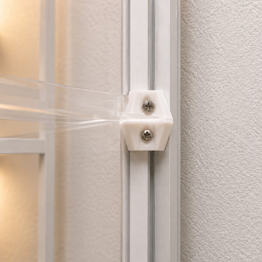 Close-up of a white cabinet with a clear plastic strip and metal bracket.