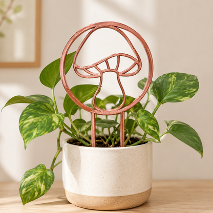 Copper silk mushroom trellis supporting climbing vines in a ceramic planter