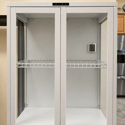 A tall white double-door storage cabinet with wire shelves, shown in a kitchen setting with a stainless steel refrigerator visible on the right.