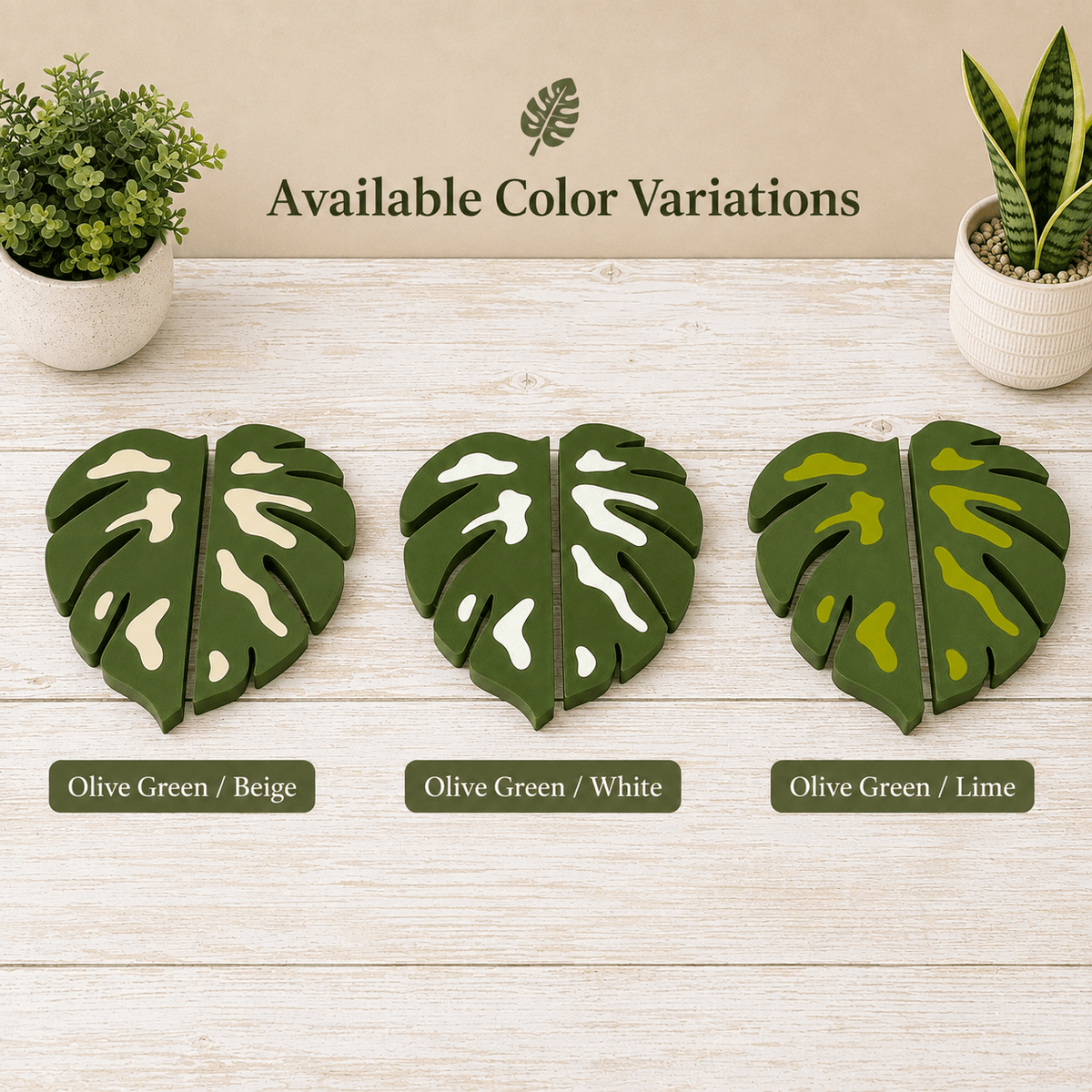 Three pairs of split monstera leaf coasters shown on a light wood surface with the text 'Available Color Variations' above them. The coasters are labeled Olive Green / Beige, Olive Green / White, and Olive Green / Lime, with small potted plants at the top corners.
