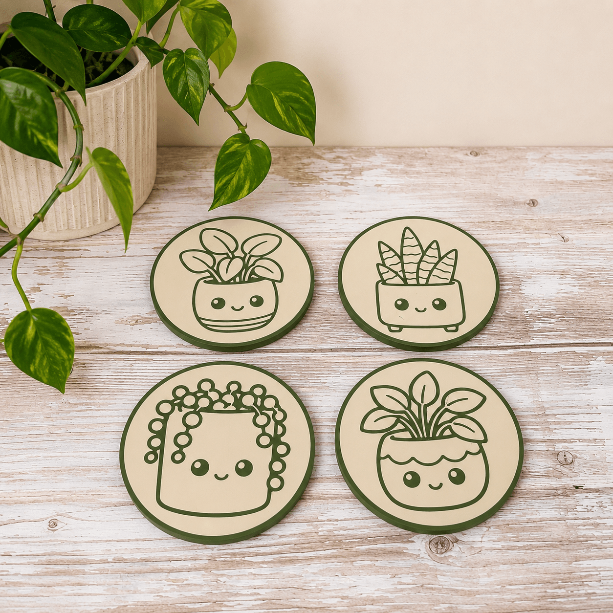 Set of four Whimlings houseplant coasters featuring Pilea, Snake Plant, String of Pearls, and Pothos