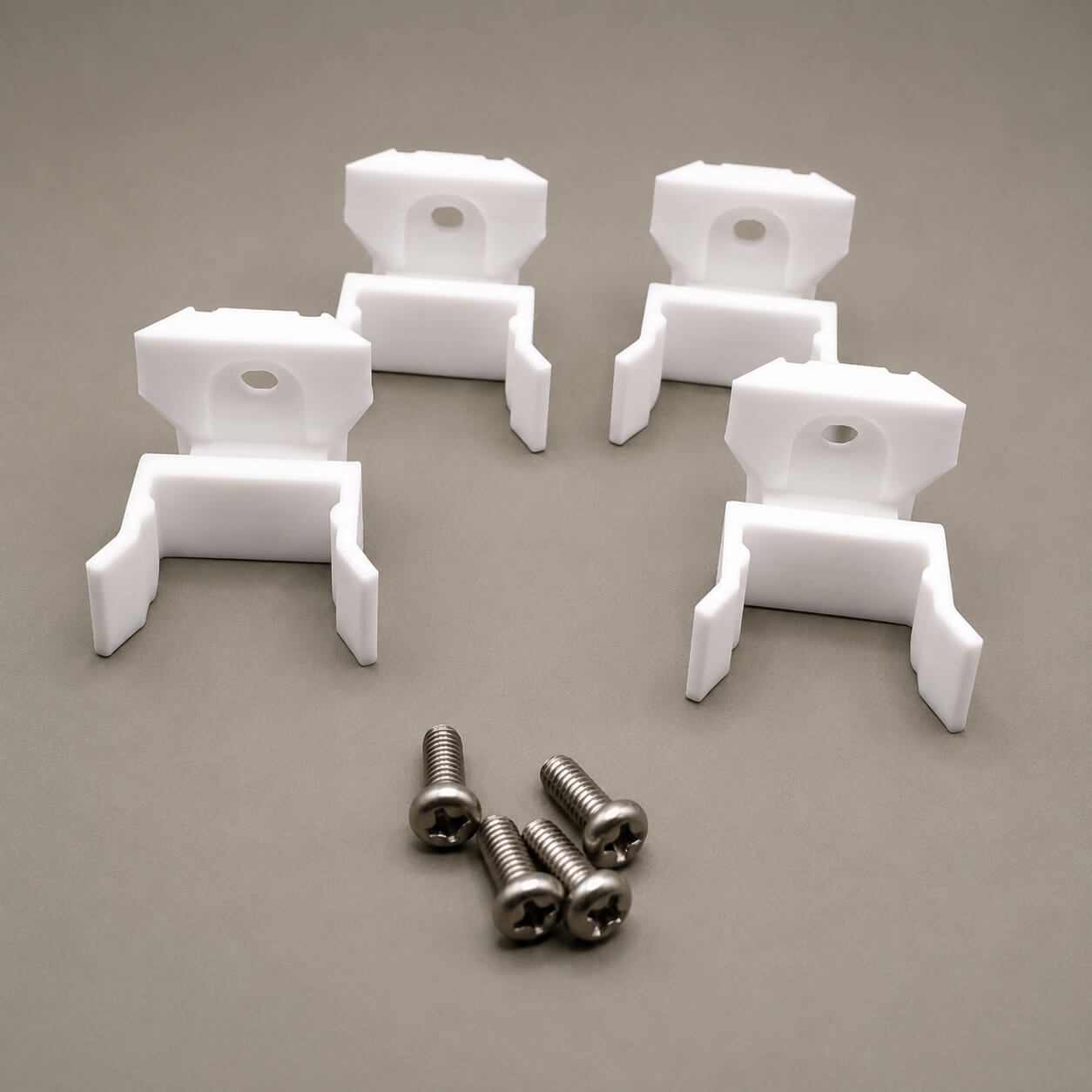 White plastic brackets with screws on a gray background