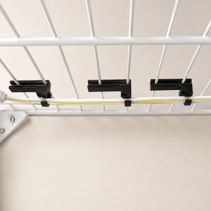 Three black cable clips holding a yellow cable beneath a white wire rack, shown against a plain beige background.