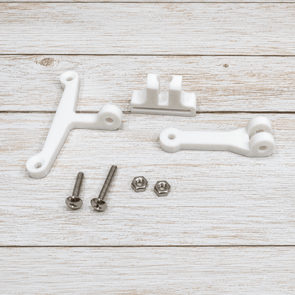 Three white plastic mounting brackets with silver screws, nuts, and washers, arranged on a light whitewashed wooden background.